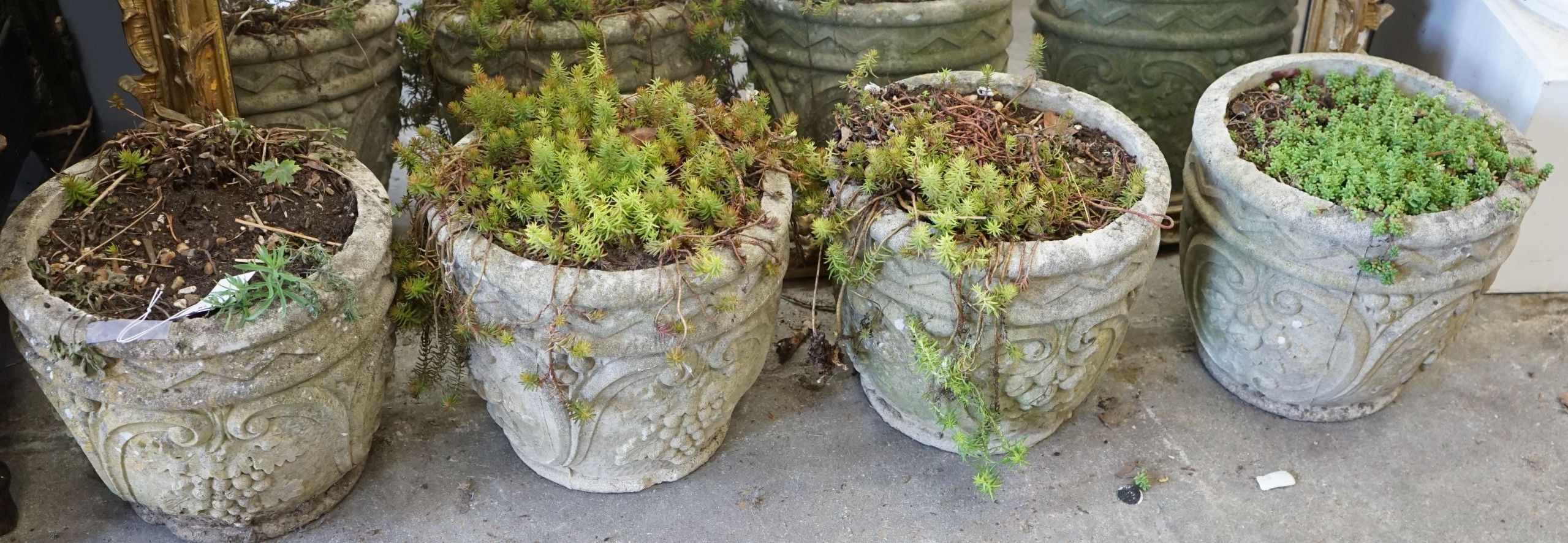 A set of four circular reconstituted stone garden planters, diameter 32cm, height 28cm